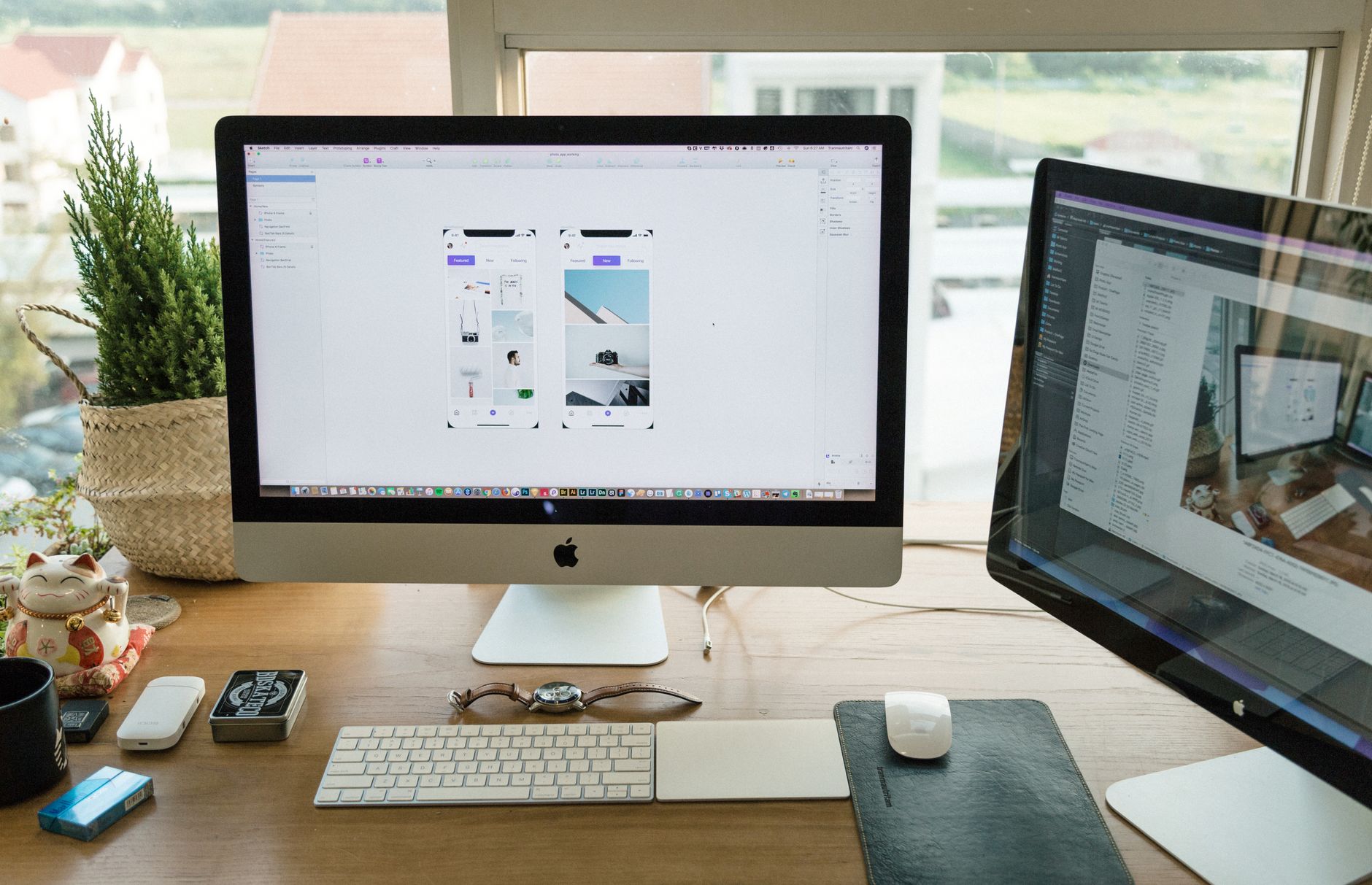 Pessoa trabalhando em computador iMac sobre mesa de madeira