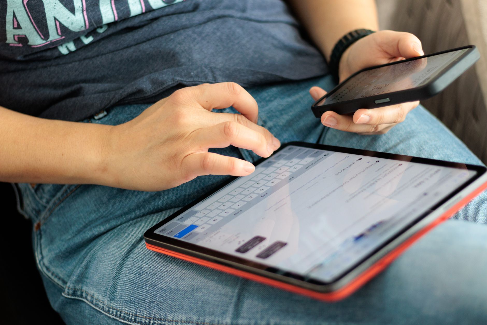 Pessoa digitando em um smartphone e tablet