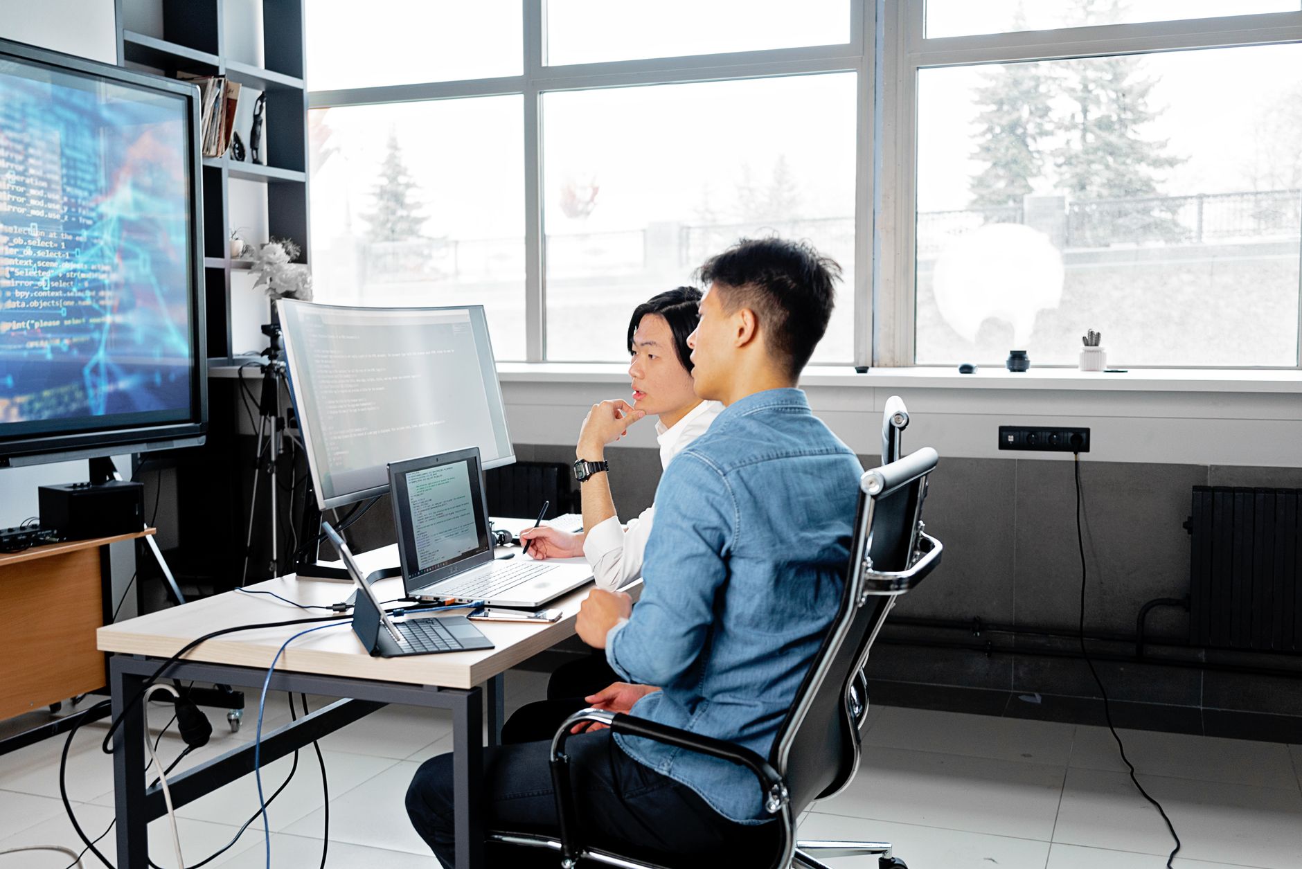 Pessoas revisando código e planejamento em tela de computador