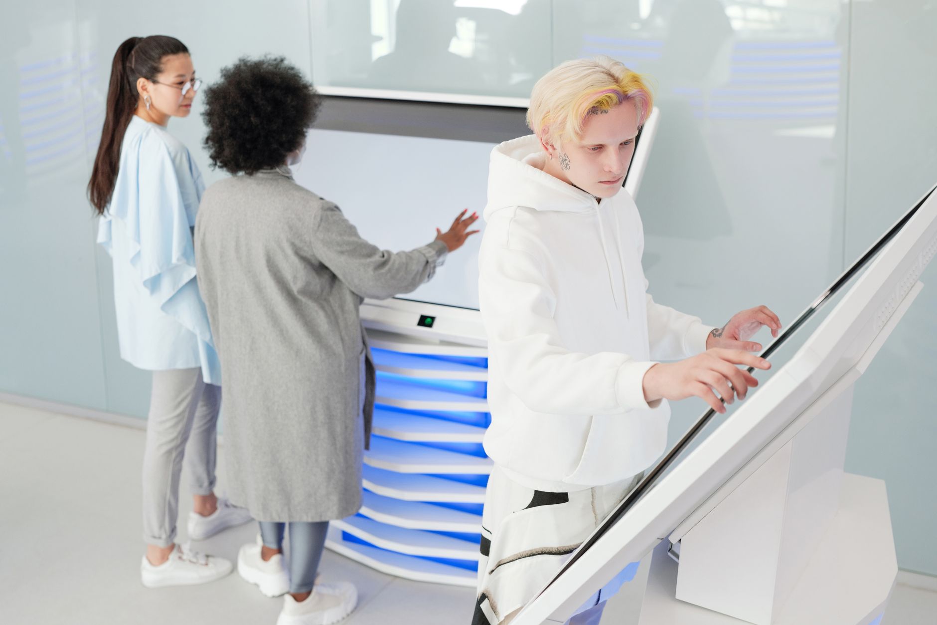 Pessoas em pé observando telas grandes em ambiente corporativo moderno