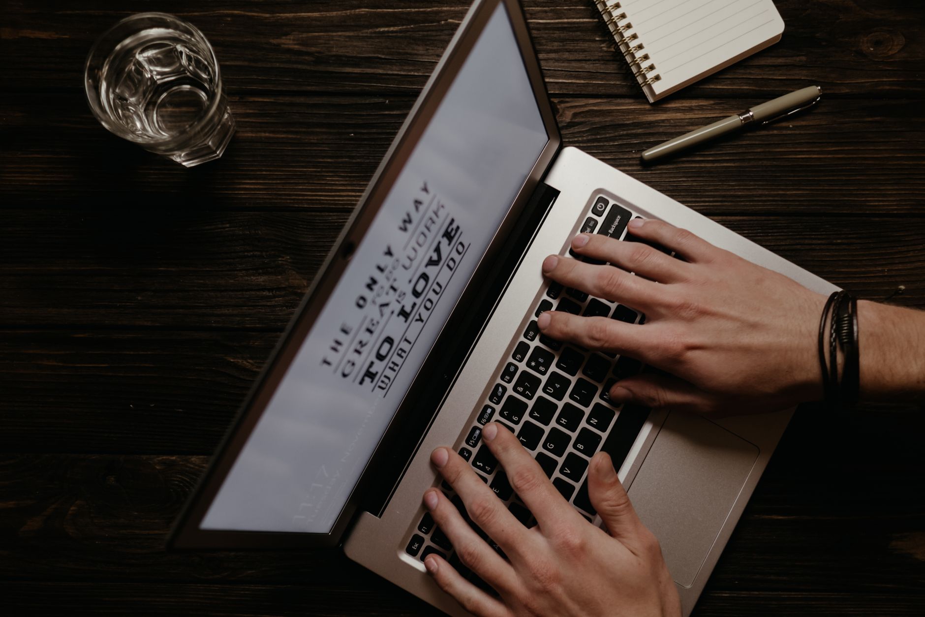 Pessoa digitando em laptop com xícara de café ao lado