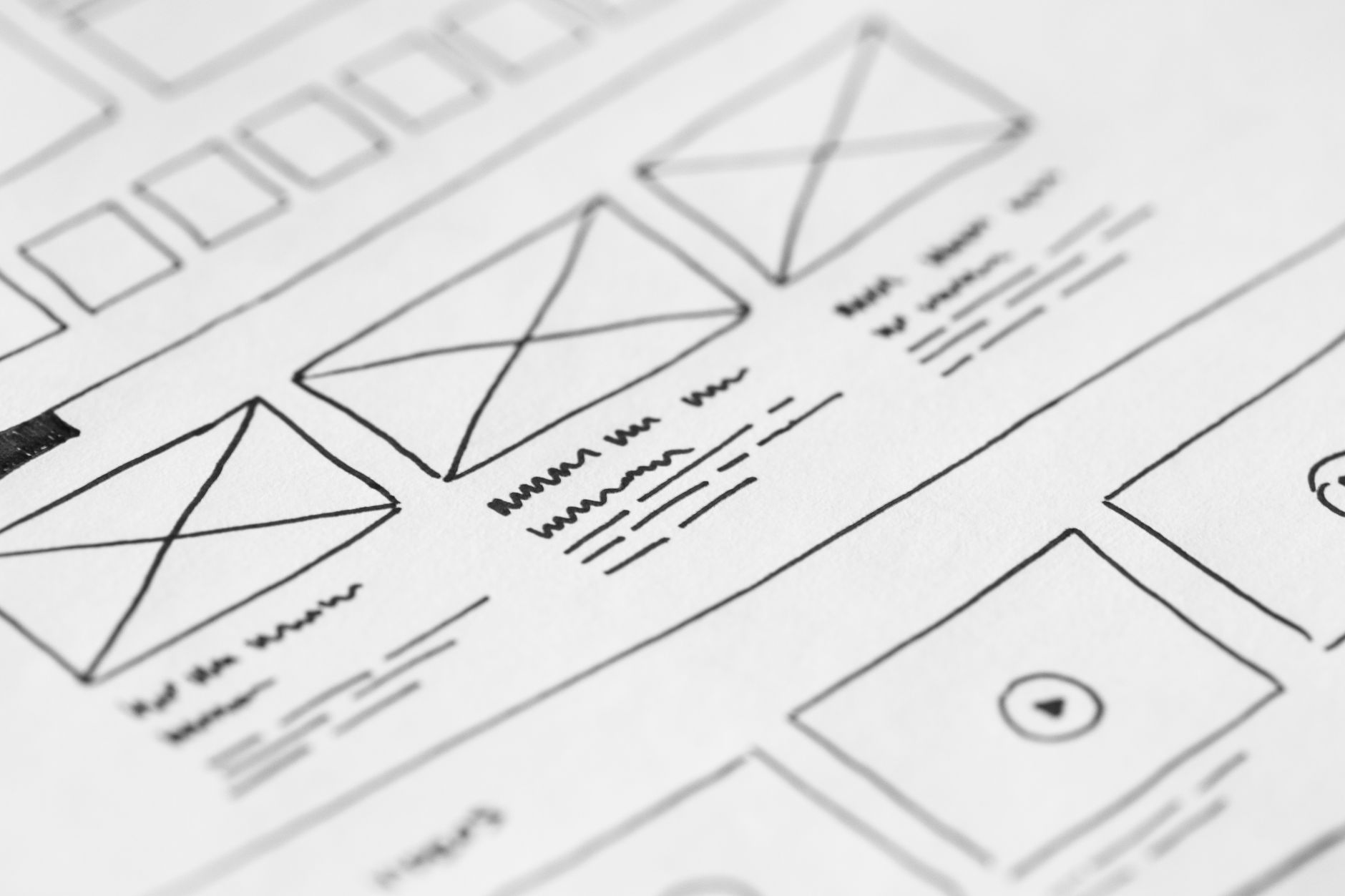 Papel em close mostrando esboço detalhado de blocos de layout para um site