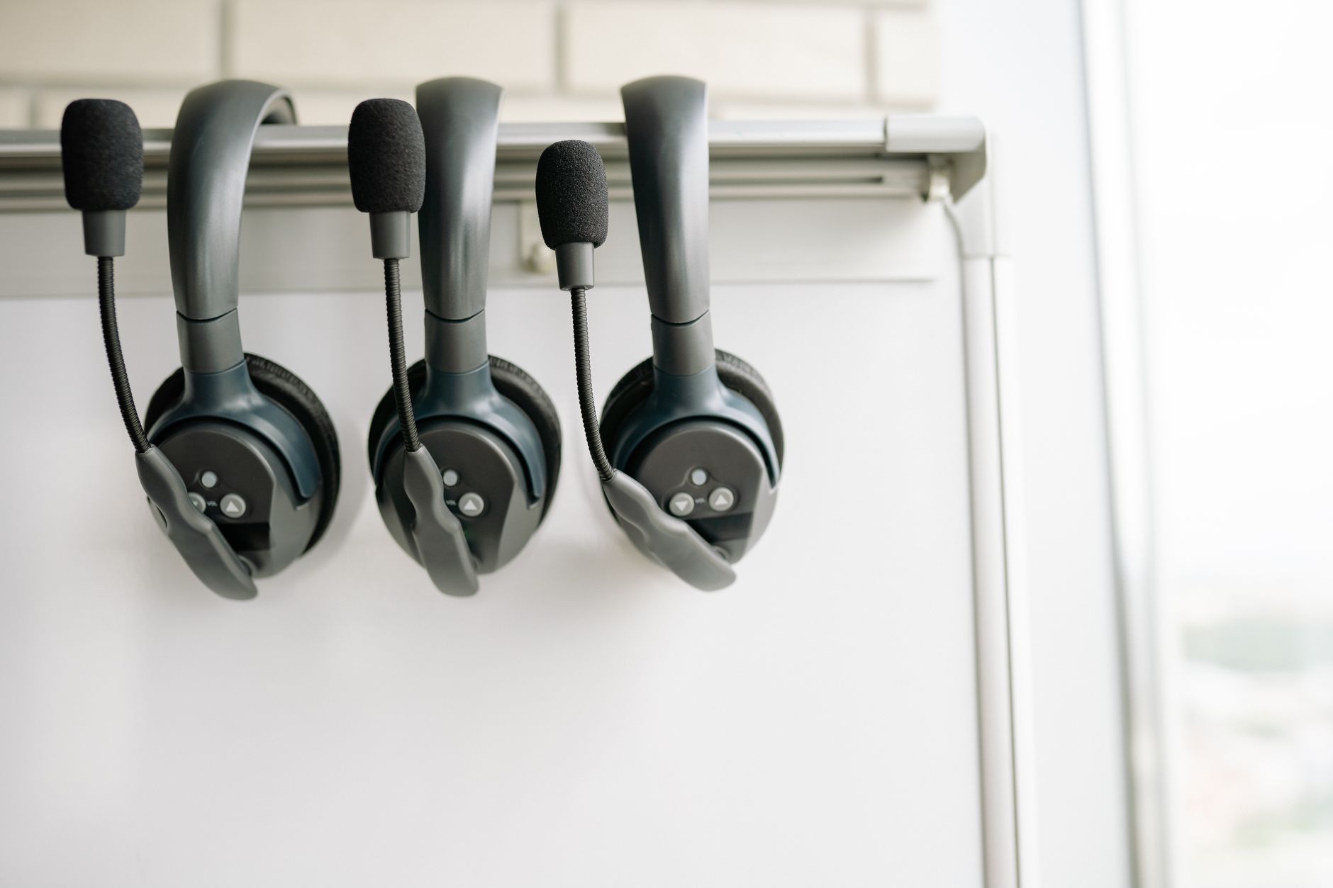 Fones de ouvido com microfone pendurados em suporte de parede