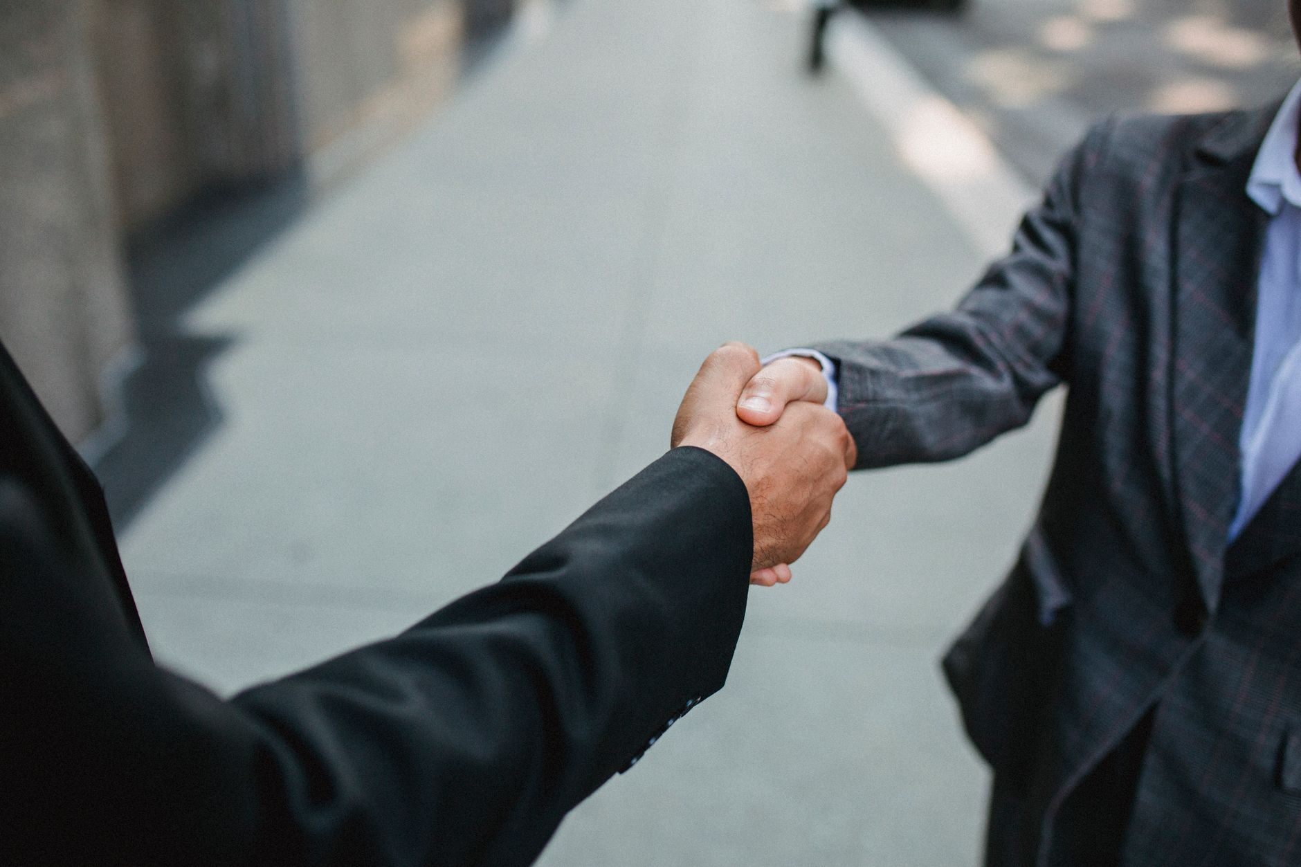 Aperto de mãos entre dois executivos em ambiente externo