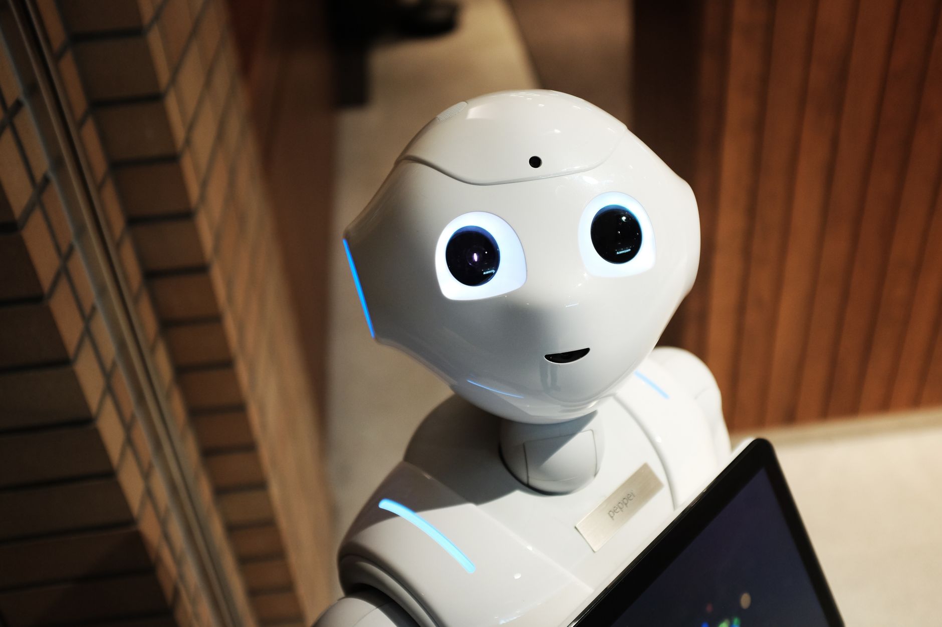 Robô assistente com tela e olhos iluminados representando um agente de inteligência artificial