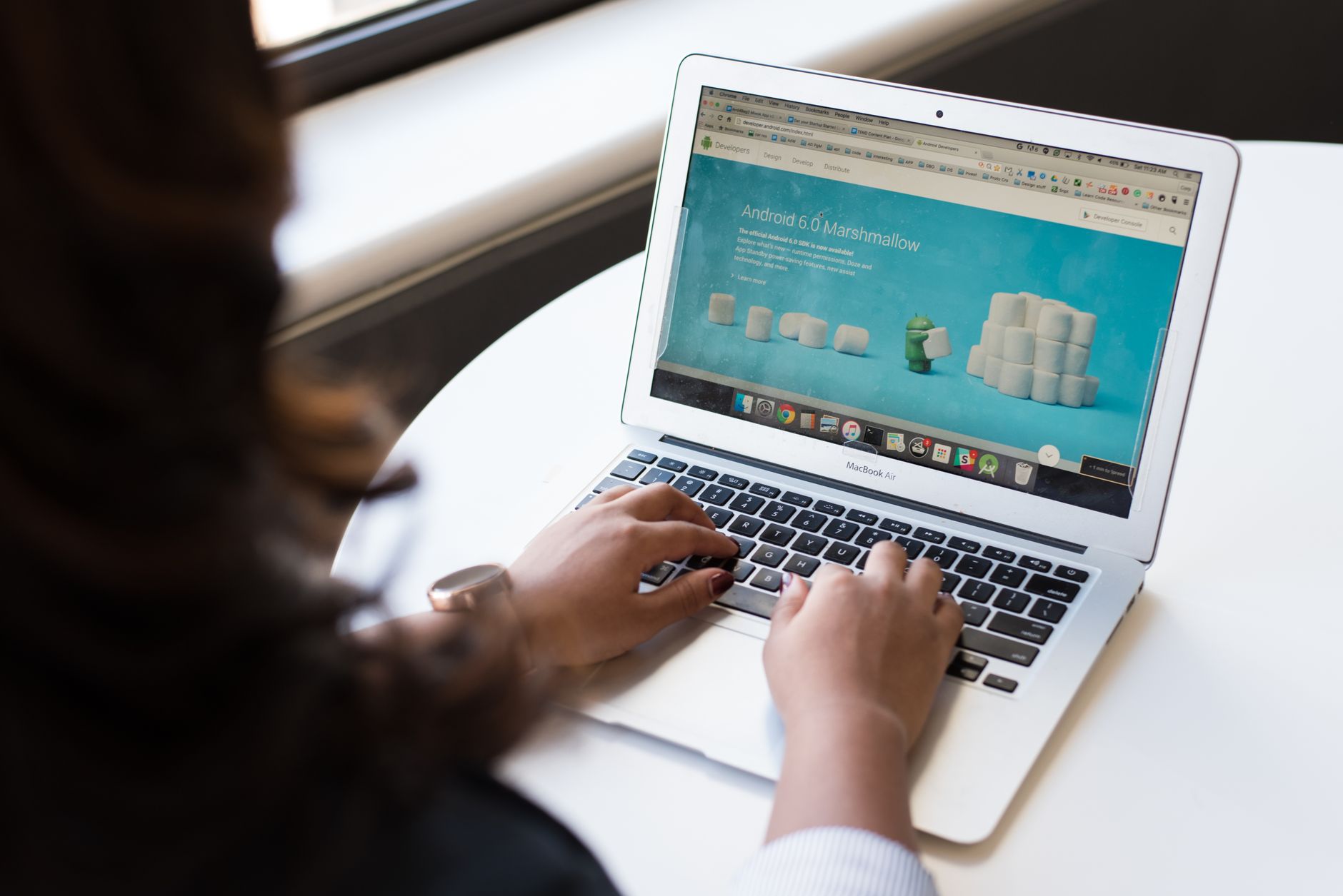Pessoa digitando em um MacBook Air com uma página de desenvolvedor Android na tela