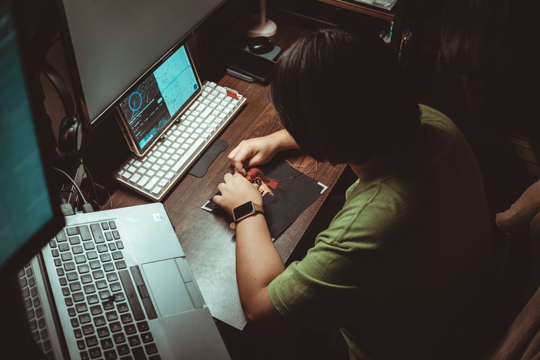 Pessoa trabalhando em um setup com notebook e monitor extra em um escritório doméstico